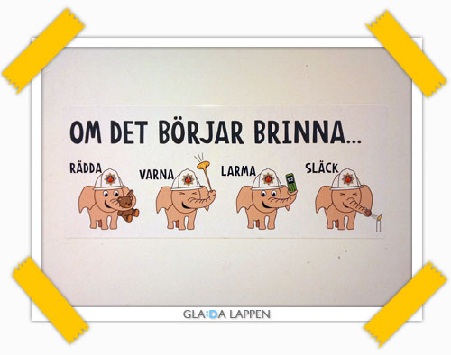 En liten glad lapp med glada elefanter med brandhjälmar som påminner om vad du skall göra om det skulle börja brinna: RÄDDA, VARNA, LARMA, SLÄCK.